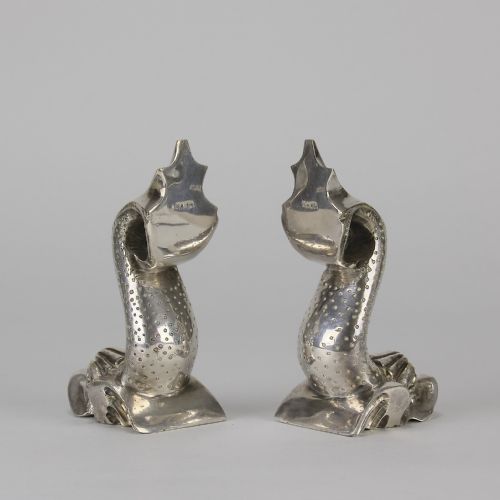 fig 4. A pair of silvered metal bookends sculpted in the shape of upright stylised fish with textured scales and curved tails.