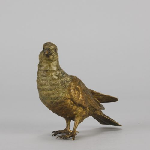 fig 2. A cold-painted bronze figurine depicting a pigeon with textured feathers and a golden finish, standing facing left.