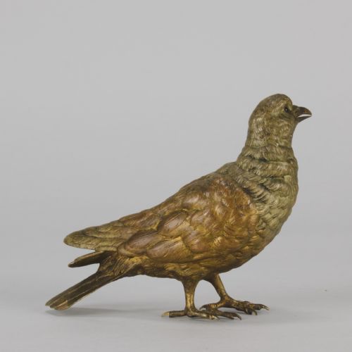 fig 3. A cold-painted bronze figurine depicting a pigeon with textured feathers and a golden finish, standing facing left.