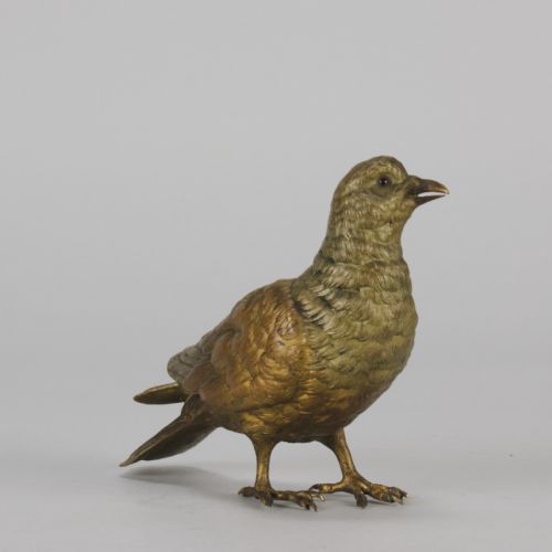 fig 4. A cold-painted bronze figurine depicting a pigeon with textured feathers and a golden finish, standing facing left.