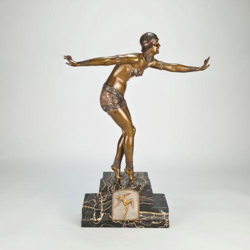 fig 2. An Art Deco gilt bronze sculpture depicting a female dancer in an elaborate costume posed dynamically on a stepped black marbled base.