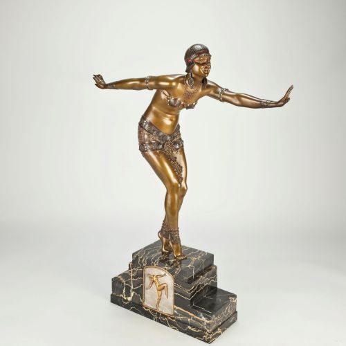 fig 3. An Art Deco gilt bronze sculpture depicting a female dancer in an elaborate costume posed dynamically on a stepped black marbled base.