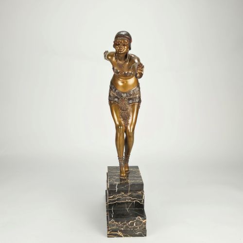fig 4. An Art Deco gilt bronze sculpture depicting a female dancer in an elaborate costume posed dynamically on a stepped black marbled base.