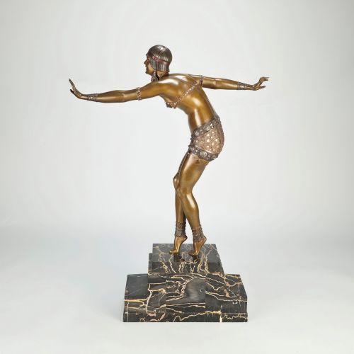fig 6. An Art Deco gilt bronze sculpture depicting a female dancer in an elaborate costume posed dynamically on a stepped black marbled base.