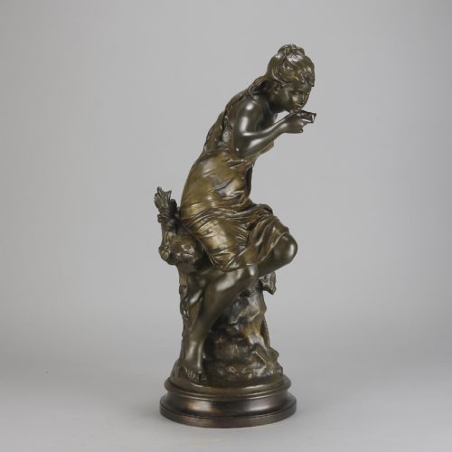 fig 1. A 19th-century dark bronze sculpture of a draped female figure seated on a rocky outcrop, mounted on a circular moulded base.