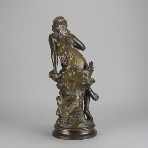 fig 2. A 19th-century dark bronze sculpture of a draped female figure seated on a rocky outcrop, mounted on a circular moulded base.