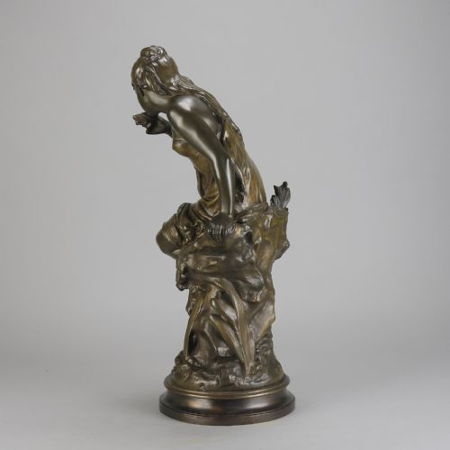 fig 3. A 19th-century dark bronze sculpture of a draped female figure seated on a rocky outcrop, mounted on a circular moulded base.