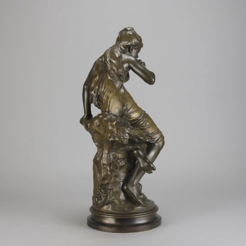 fig 5. A 19th-century dark bronze sculpture of a draped female figure seated on a rocky outcrop, mounted on a circular moulded base.