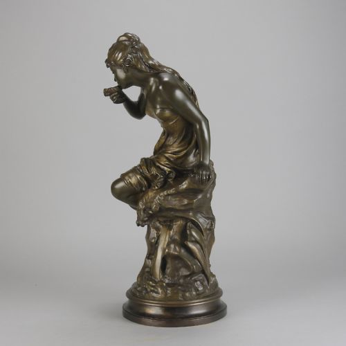 fig 6. A 19th-century dark bronze sculpture of a draped female figure seated on a rocky outcrop, mounted on a circular moulded base.
