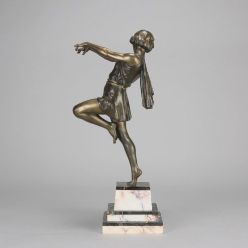 fig 2. An Art Deco bronze figurine of a female dancer captured mid-motion, mounted on a stepped variegated marble base.