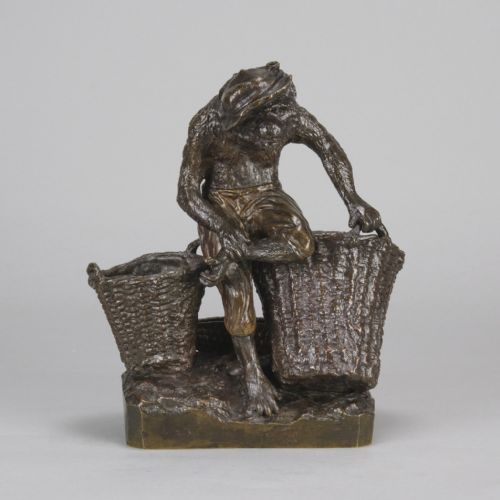 fig 2. A dark patinated bronze sculpture depicting an anthropomorphic monkey wearing trousers and a cap, standing beside two large woven baskets on a rectangular base.