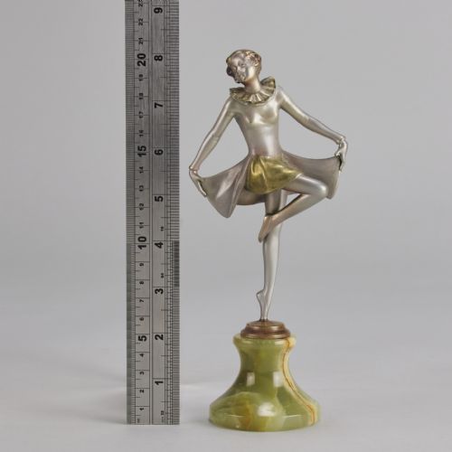 fig 4. An Art Deco cold-painted bronze figurine depicting a female dancer in a curtsy pose mounted on a green onyx base.