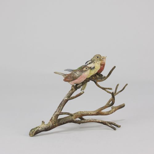 fig 2. An early 20th-century cold-painted bronze sculpture depicting four colourful small birds perched along a textured tree branch.