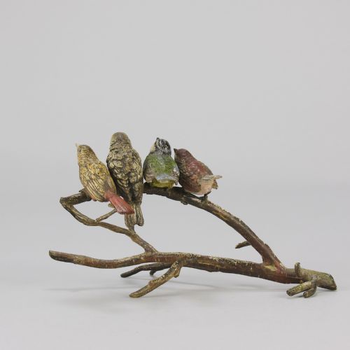 fig 5. An early 20th-century cold-painted bronze sculpture depicting four colourful small birds perched along a textured tree branch.