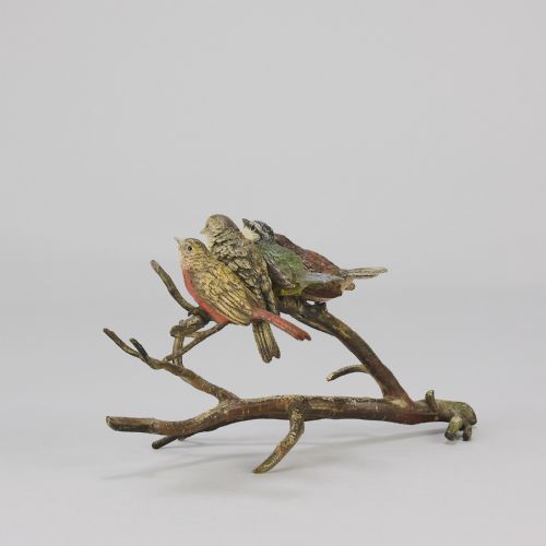 fig 6. An early 20th-century cold-painted bronze sculpture depicting four colourful small birds perched along a textured tree branch.