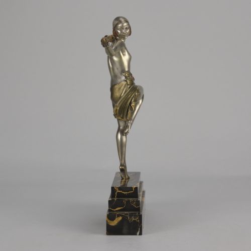 fig 3. An Art Deco cold-painted metal sculpture of a female dancer holding a staff, posed dynamically on a stepped black and gold marble base.