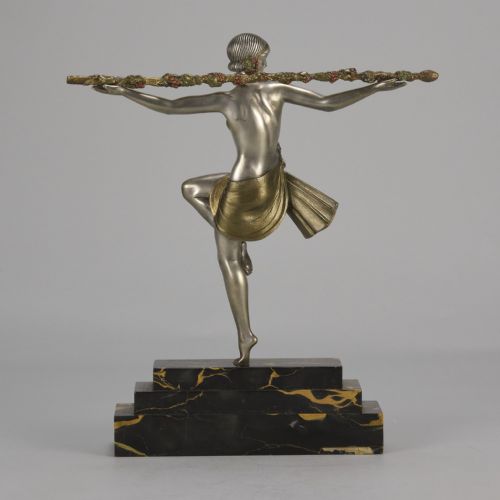 fig 5. An Art Deco cold-painted metal sculpture of a female dancer holding a staff, posed dynamically on a stepped black and gold marble base.