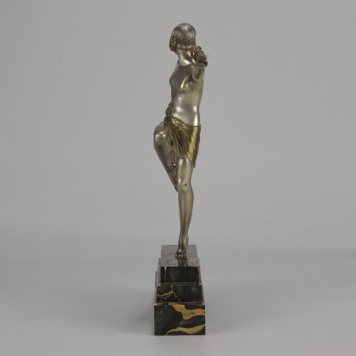 fig 6. An Art Deco cold-painted metal sculpture of a female dancer holding a staff, posed dynamically on a stepped black and gold marble base.