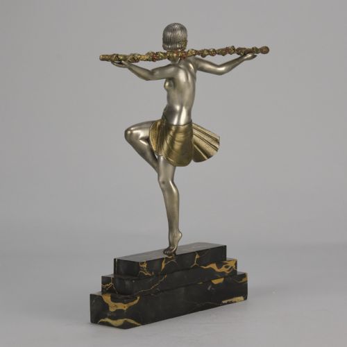fig 7. An Art Deco cold-painted metal sculpture of a female dancer holding a staff, posed dynamically on a stepped black and gold marble base.