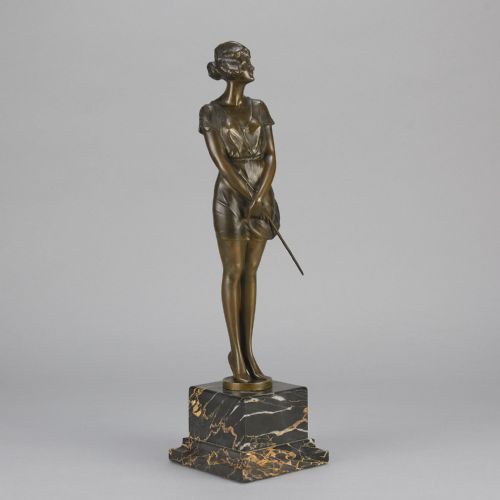 fig 2. An Art Deco bronze statue of a standing woman holding a crop, mounted on a square black marble pedestal.