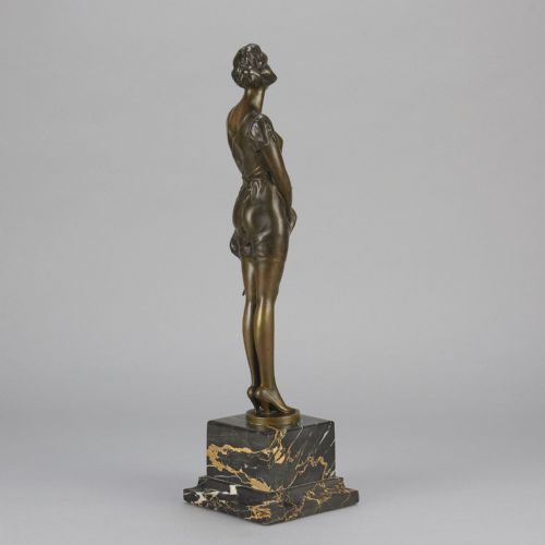 fig 4. An Art Deco bronze statue of a standing woman holding a crop, mounted on a square black marble pedestal.