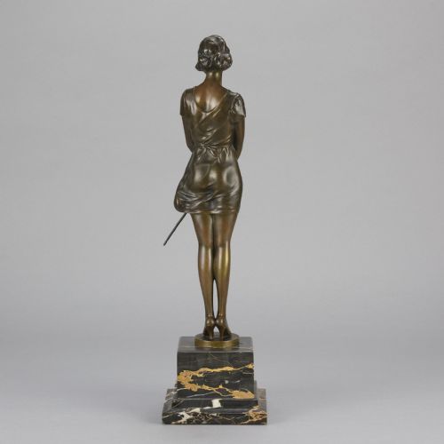 fig 5. An Art Deco bronze statue of a standing woman holding a crop, mounted on a square black marble pedestal.