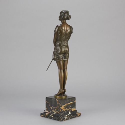 fig 6. An Art Deco bronze statue of a standing woman holding a crop, mounted on a square black marble pedestal.