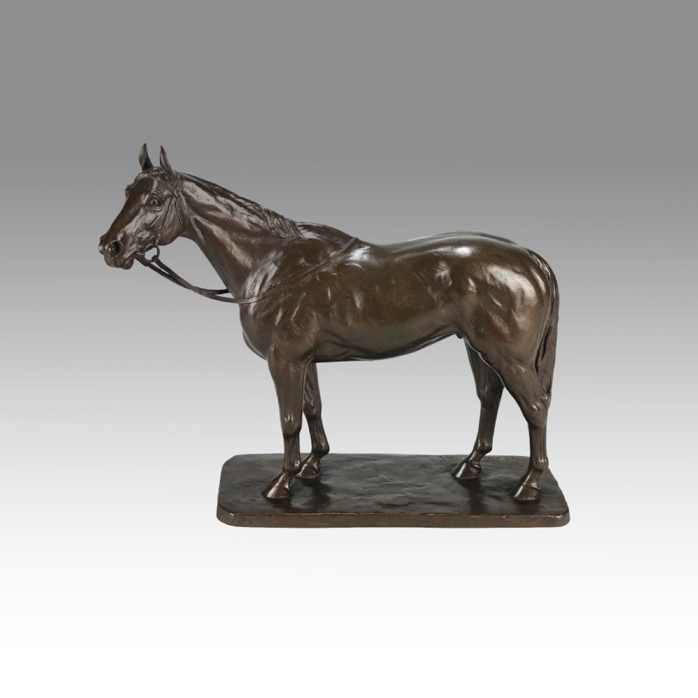 A dark brown bronze sculpture of a standing horse with a detailed bridle and reins, mounted on a flat rectangular bronze base. View XII