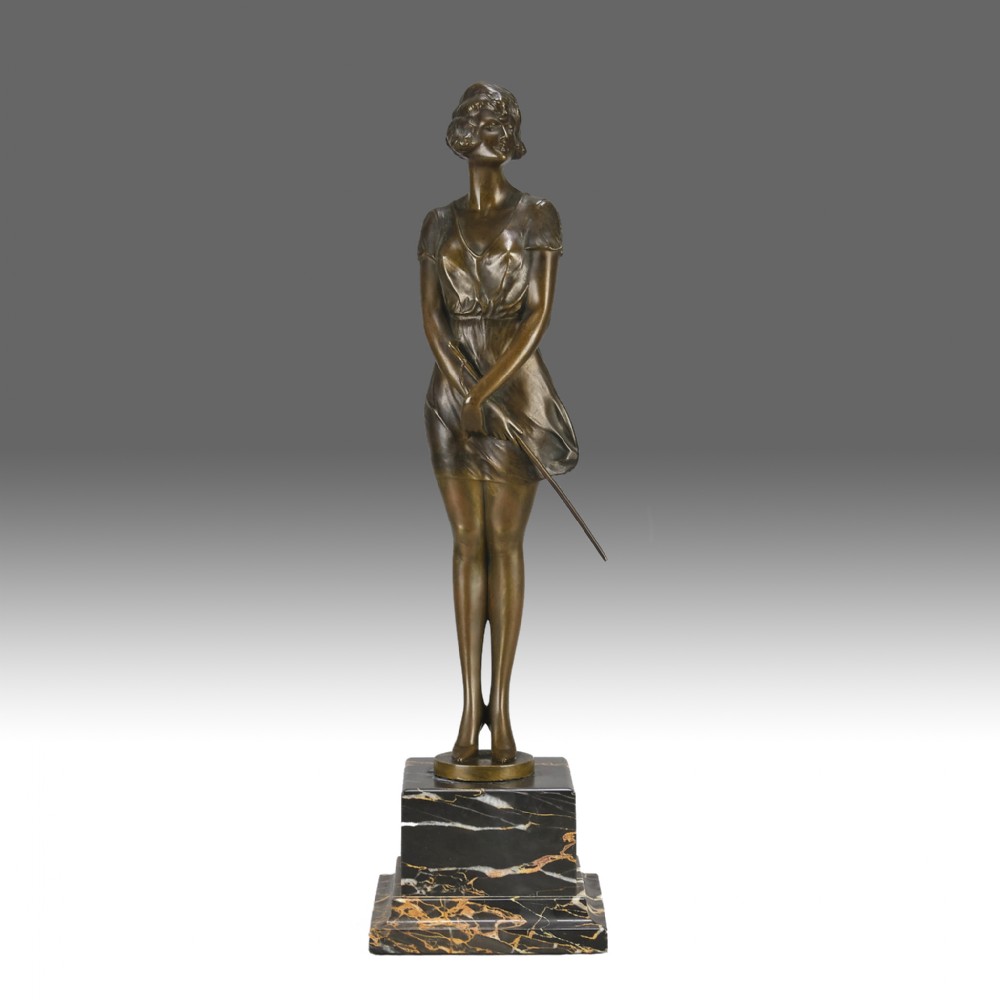 An Art Deco bronze statue of a standing woman holding a crop, mounted on a square black marble pedestal.