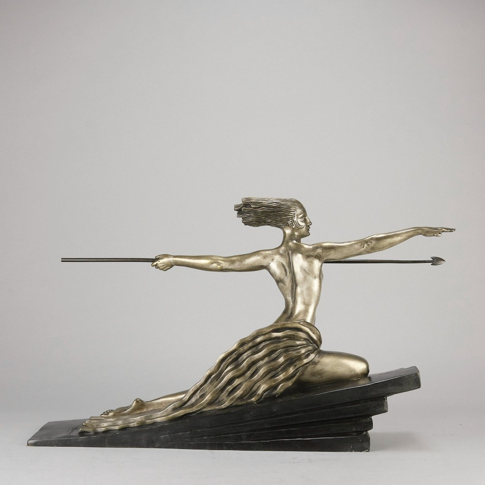 An Art Deco silvered metal sculpture depicting a stylized female archer holding a spear, mounted on a stepped black base. View VI