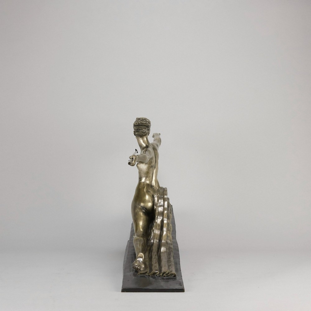 An Art Deco silvered metal sculpture depicting a stylized female archer holding a spear, mounted on a stepped black base. View VIII