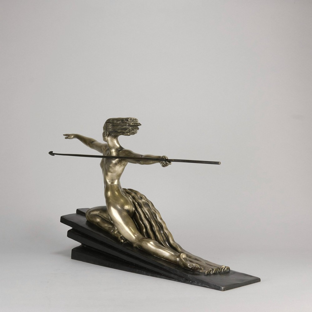 An Art Deco silvered metal sculpture depicting a stylized female archer holding a spear, mounted on a stepped black base. View IX