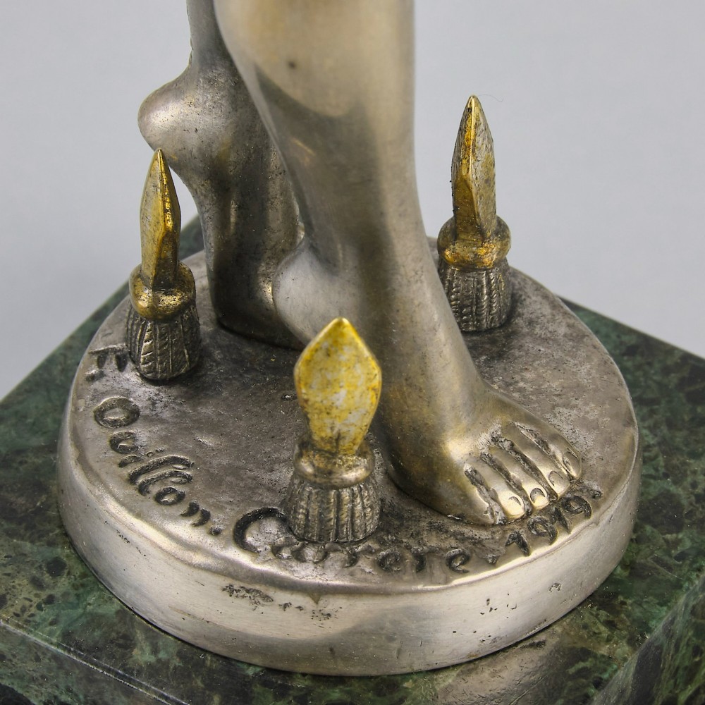 An Art Deco silver-toned cold-painted bronze sculpture depicting a standing female dancer raised on a dark green marble pedestal base. View X