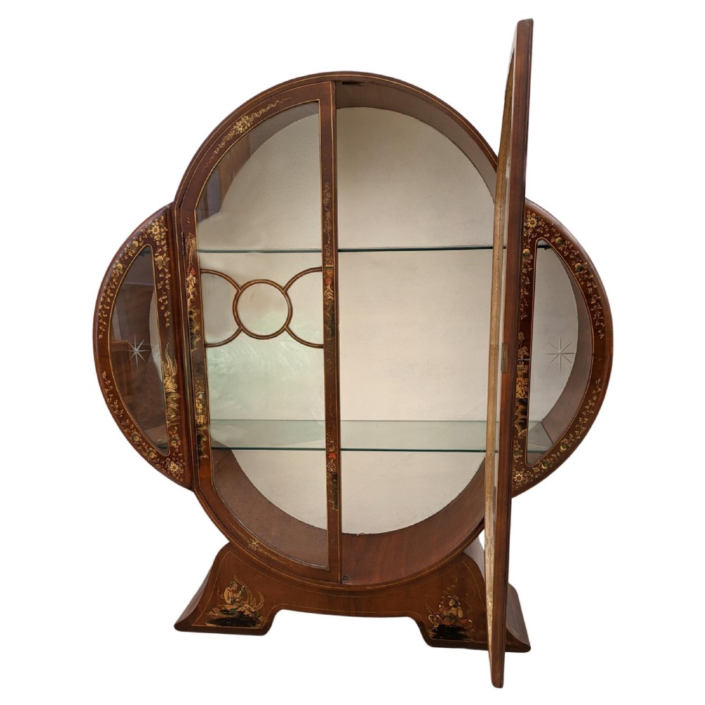 A 1930s Art Deco mahogany display cabinet featuring a circular silhouette with hand-painted gilt Chinoiserie details and glazed double doors. View II
