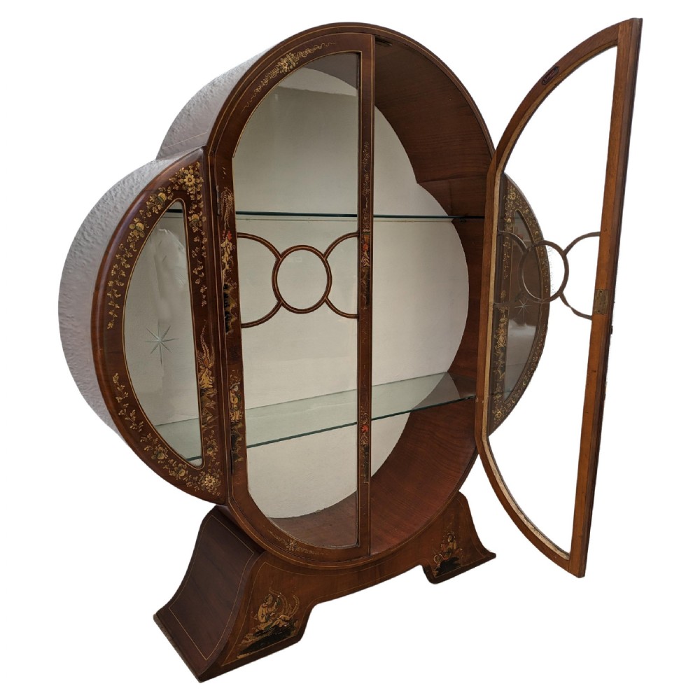 A 1930s Art Deco mahogany display cabinet featuring a circular silhouette with hand-painted gilt Chinoiserie details and glazed double doors. View V
