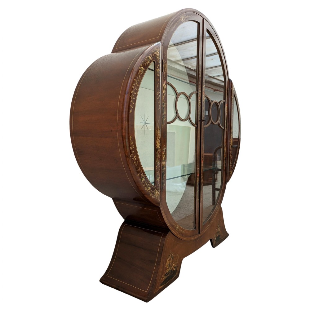 A 1930s Art Deco mahogany display cabinet featuring a circular silhouette with hand-painted gilt Chinoiserie details and glazed double doors. View VII