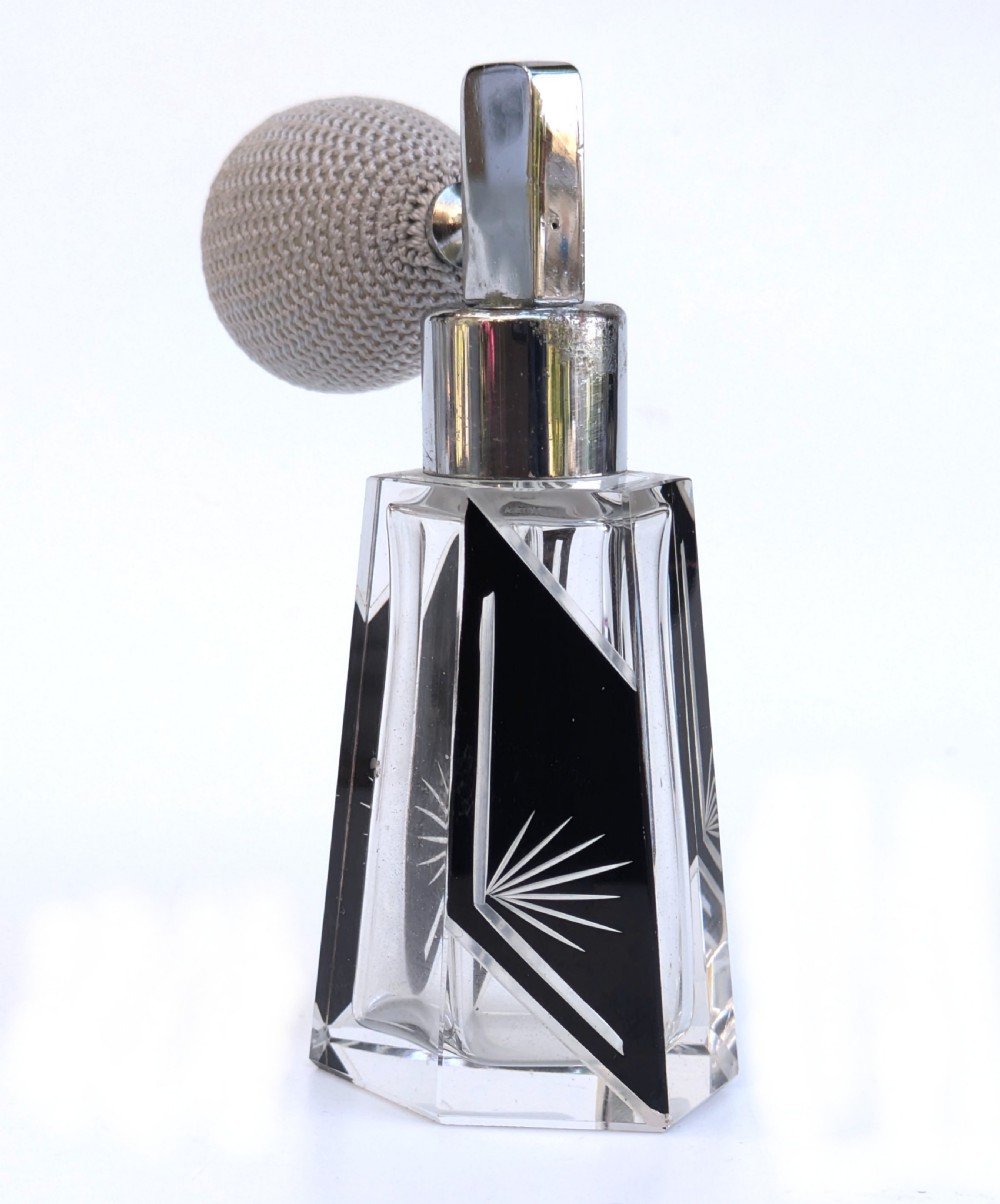 A geometric clear glass Art Deco perfume atomiser bottle featuring black enamel panels, etched sunburst motifs, a chrome spray nozzle, and a grey woven fabric bulb. View V