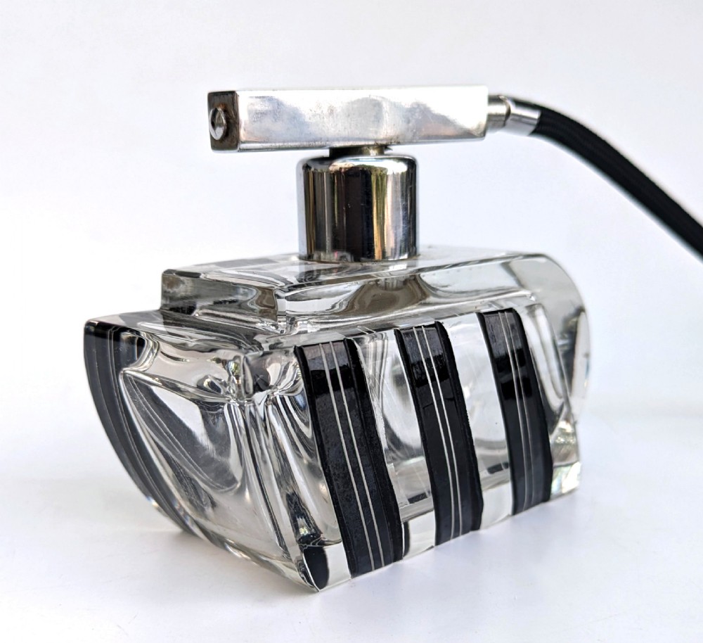An Art Deco clear glass perfume atomiser featuring painted black geometric stripes, chrome metal hardware, and a black fabric squeeze bulb with a long tassel. View IV