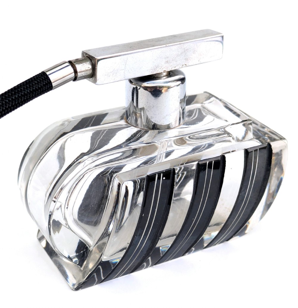 An Art Deco clear glass perfume atomiser featuring painted black geometric stripes, chrome metal hardware, and a black fabric squeeze bulb with a long tassel. View VII