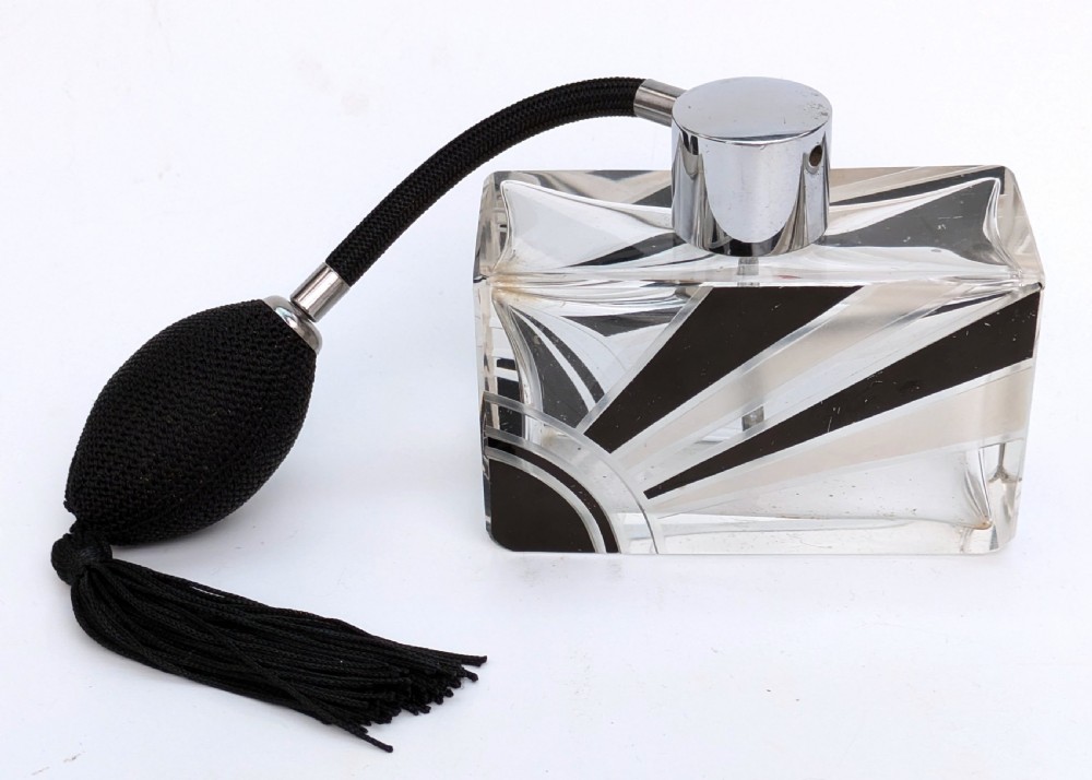 An Art Deco rectangular cut glass perfume atomiser featuring a black enamelled sunray pattern and a chrome top connected to a black fabric bulb with a tassel. View II