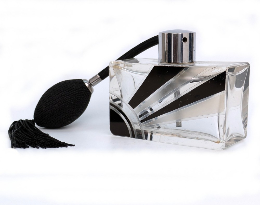 An Art Deco rectangular cut glass perfume atomiser featuring a black enamelled sunray pattern and a chrome top connected to a black fabric bulb with a tassel. View III