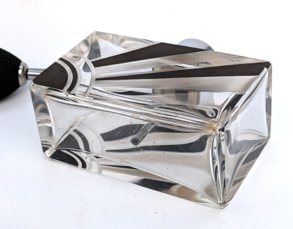 An Art Deco rectangular cut glass perfume atomiser featuring a black enamelled sunray pattern and a chrome top connected to a black fabric bulb with a tassel. View VI