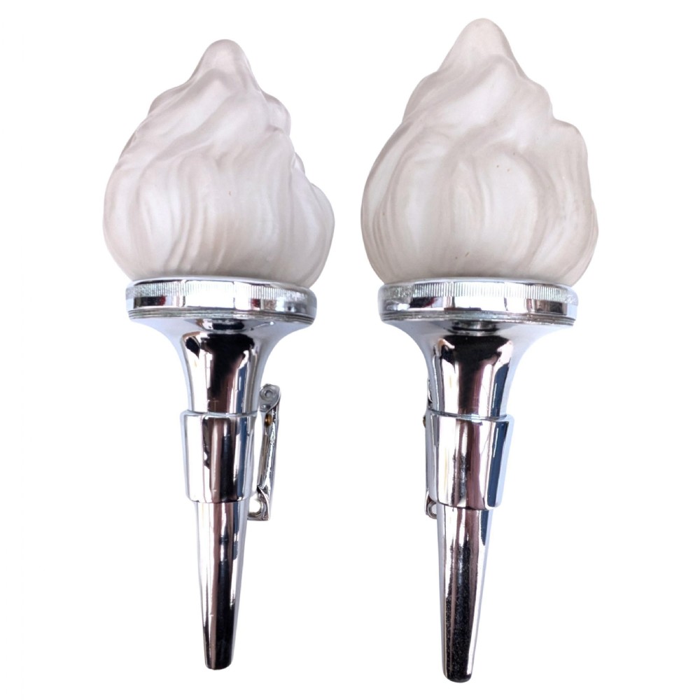 A matching pair of 1930s Art Deco wall lights featuring polished chrome torch-shaped mounts and flame-moulded frosted glass shades.