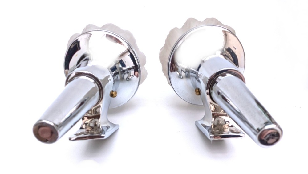 A matching pair of 1930s Art Deco wall lights featuring polished chrome torch-shaped mounts and flame-moulded frosted glass shades. View VI