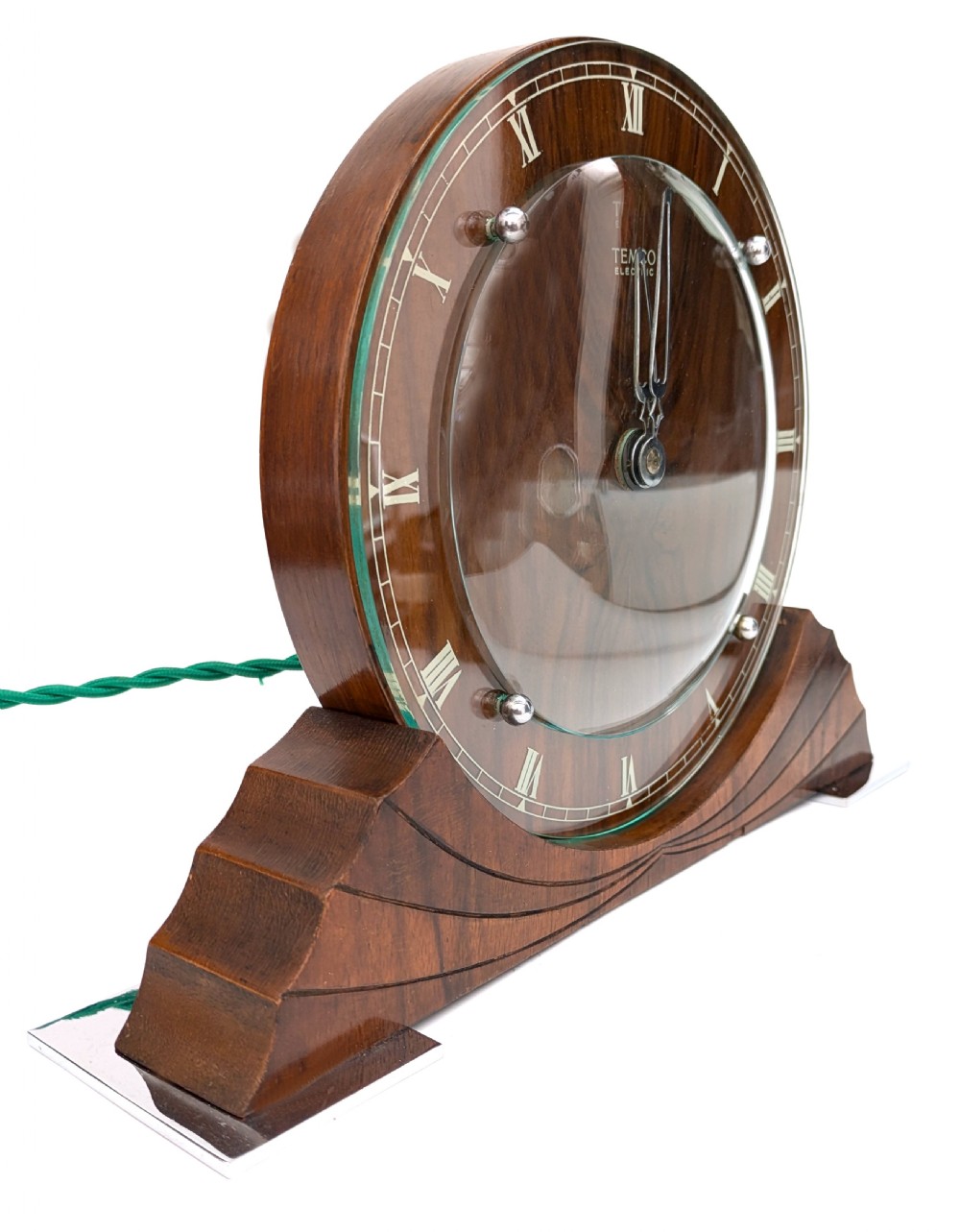 An Art Deco circular walnut mantel clock featuring inlaid Roman numerals and a stepped contoured base. View II