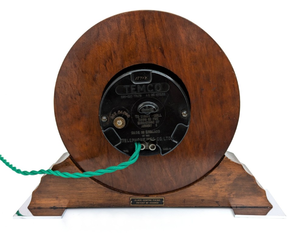 An Art Deco circular walnut mantel clock featuring inlaid Roman numerals and a stepped contoured base. View VII
