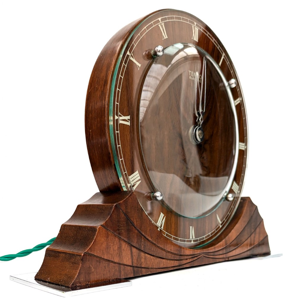 An Art Deco circular walnut mantel clock featuring inlaid Roman numerals and a stepped contoured base. View XI