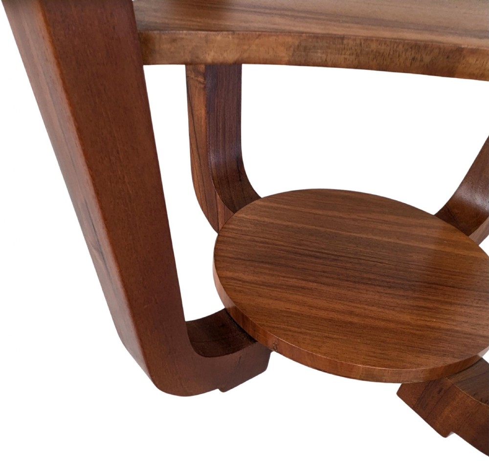 An Art Deco circular walnut occasional table featuring three tiers and angled wooden supports, showing rich grain patterns. View VII