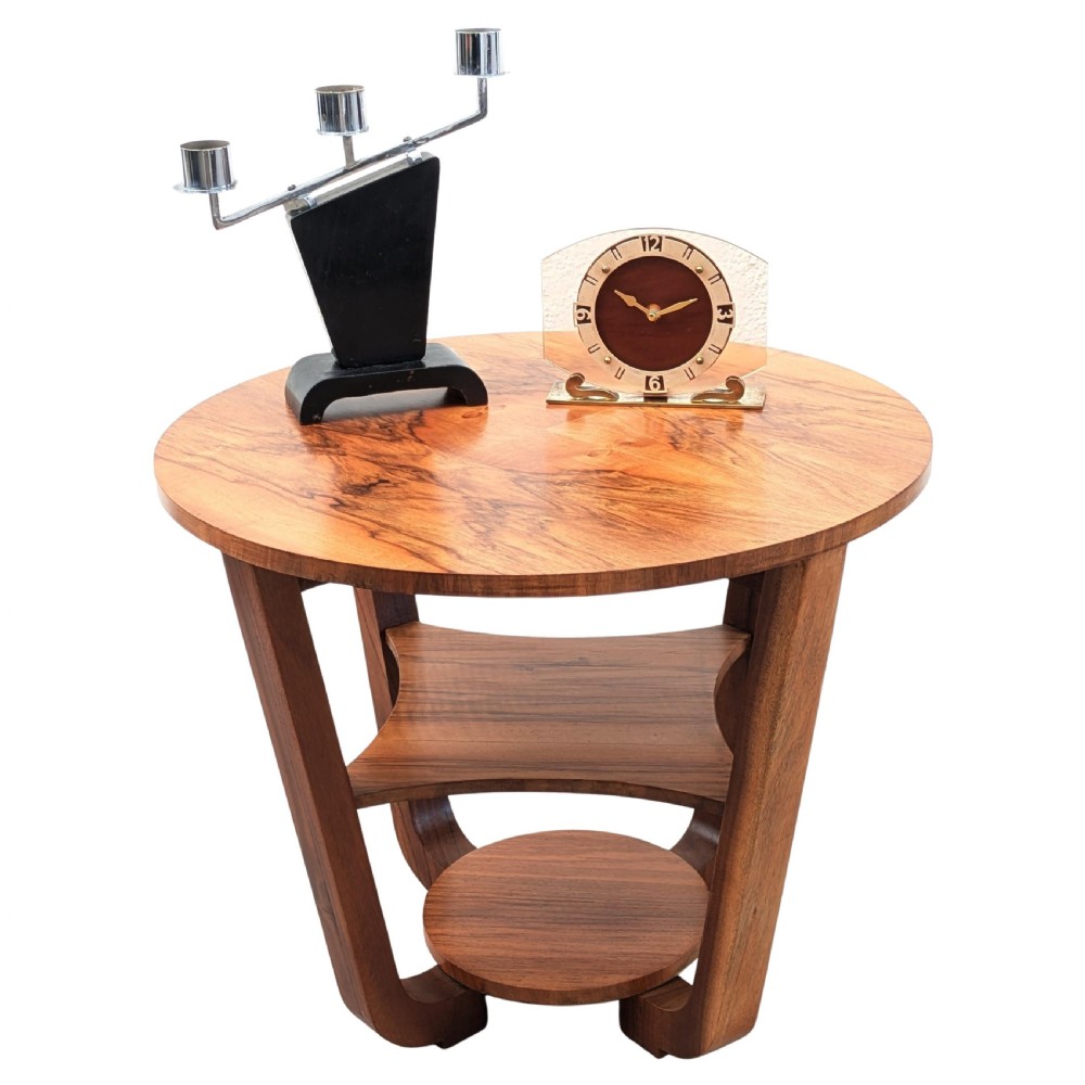 An Art Deco circular walnut occasional table featuring three tiers and angled wooden supports, showing rich grain patterns. View X