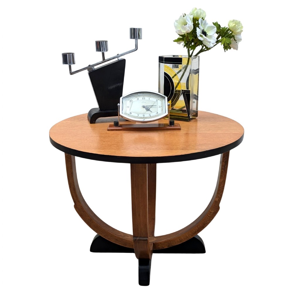 A round Art Deco blonde oak coffee table featuring sweeping curved legs and contrasting ebonised rim and cross base. View VI